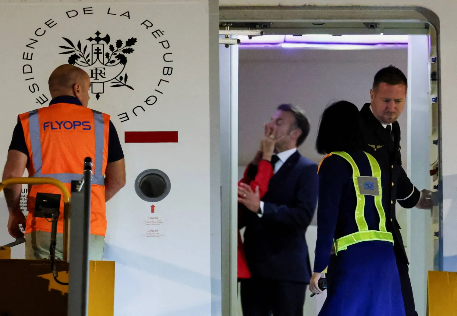 الرئيس الفرنسي إيمانويل ماكرون لدى تعرضه لدفعه في الوجه من جانب زوجته بريجيت لدى وصولهما إلى فيتنام (رويترز)