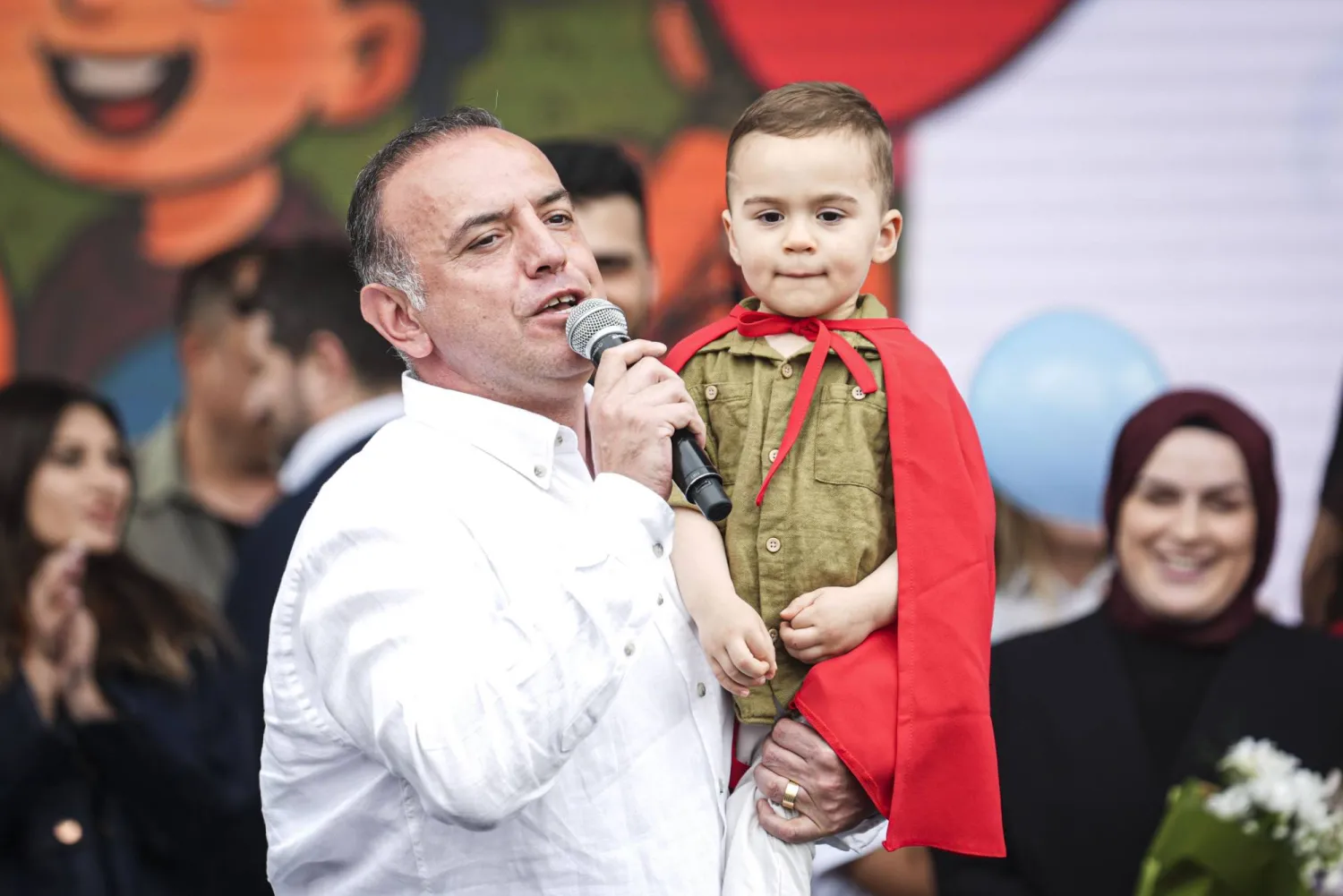 صورة مثبتة من مقطع فيديو للأب وهو يحمل ابنه عليّ وسط احتفالية بمناسبة شفائه من السرطان