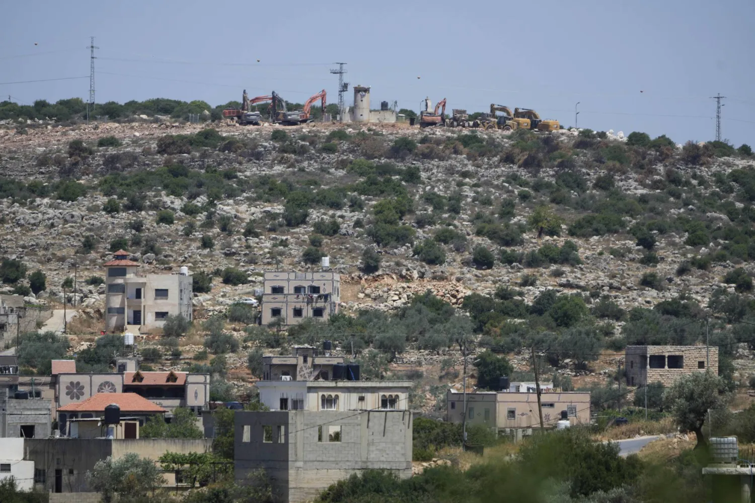 جرافات قرب مستوطنة بروخين الإسرائيلية على قمة تلة مطلة على قرية بروقين الفلسطينية بالضفة الغربية 23 مايو 2025 (أ.ب)