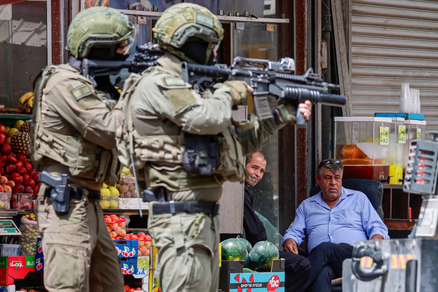 Israeli troops aim their rifles during a raid in the heart of the Palestinian city Nablus in the occupied West Bank on May 27, 2025. (Photo by Jaafar ASHTIYEH / AFP)