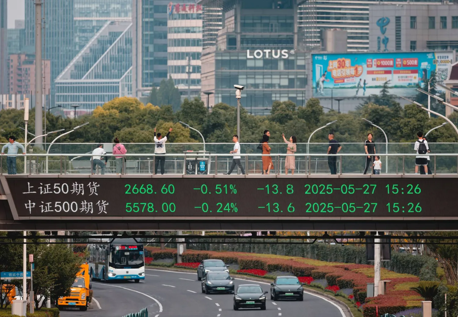 شاشة تعرض حركة الأسهم على جسر في مدينة شنغهاي الصينية (إ.ب.أ)