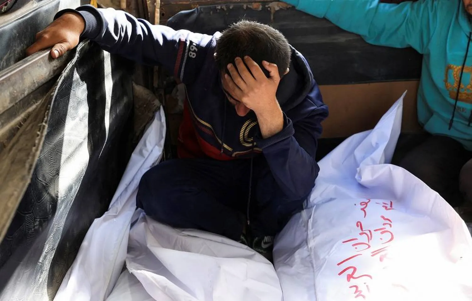 A mourner reacts besides the bodies of members of the Al-Arabeed family killed in Israeli strikes, at Al Shifa hospital, in Gaza City, May 28, 2025. (Reuters)
