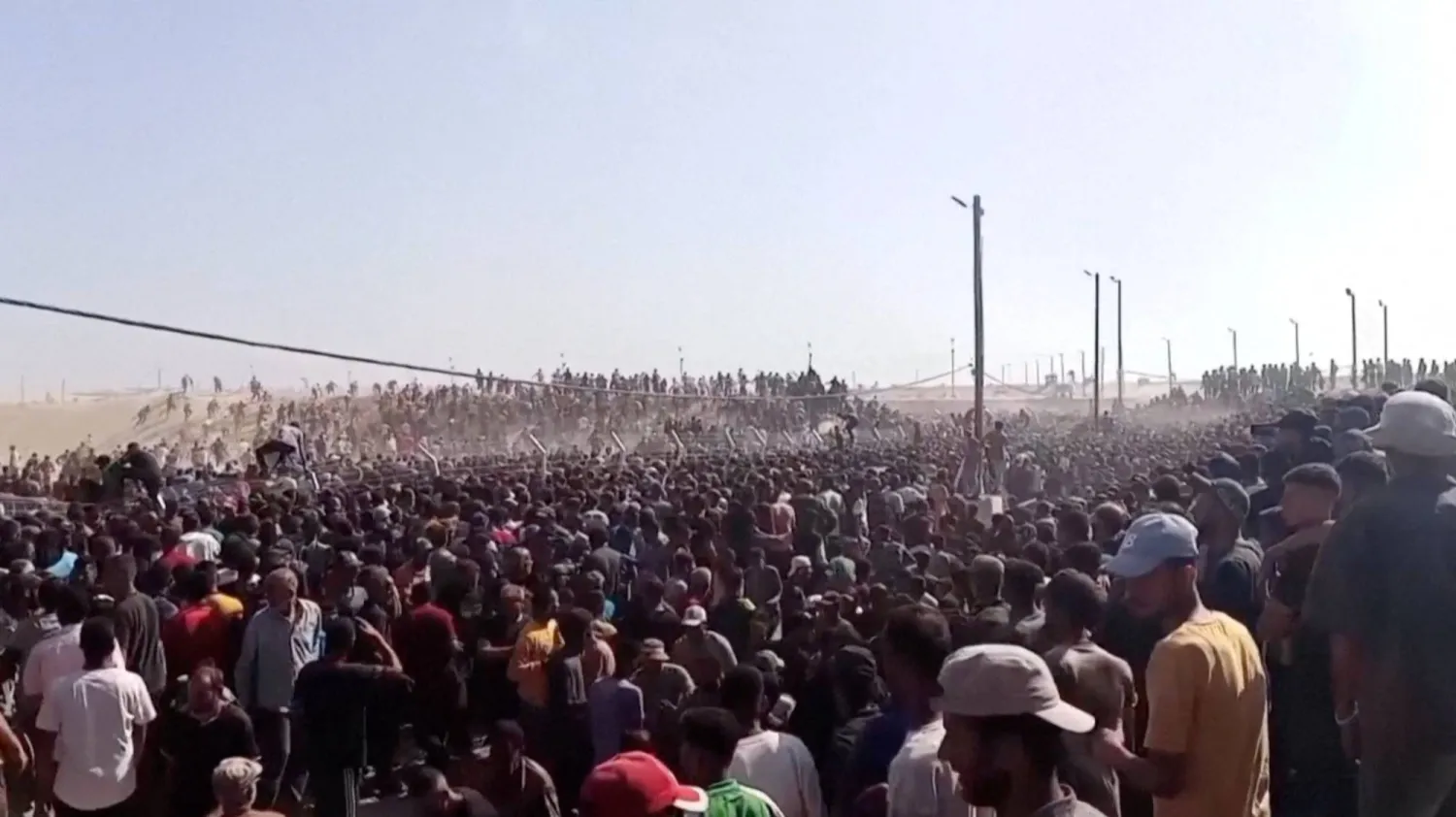 حشود من الفلسطينيين خلال توزيع مساعدات إنسانية في جنوب غزة (رويترز)