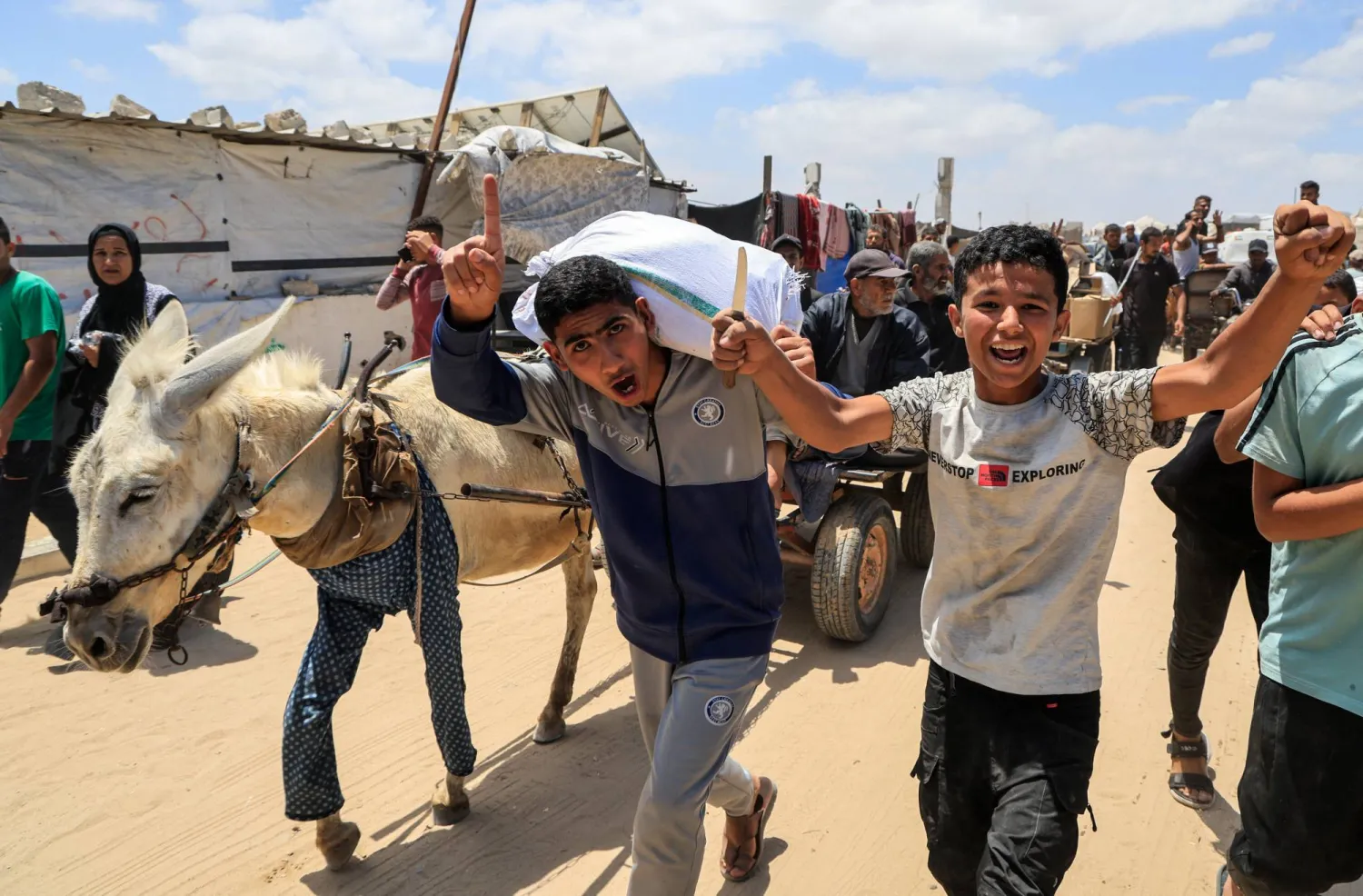 فلسطينيون يحملون إمدادات مساعدات تلقوها من مؤسسة غزة الإنسانية المدعومة من الولايات المتحدة في خان يونس (رويترز)