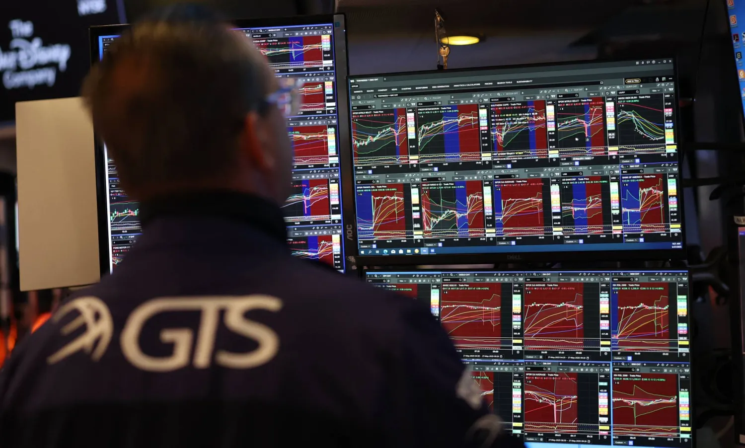 متداول يراقب شاشة تعرض مؤشرات الأسهم في بورصة نيويورك (أ.ف.ب)