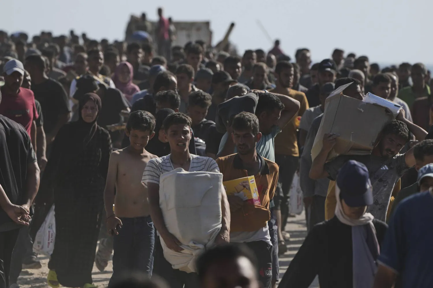 فلسطينيون يحملون صناديق تحتوي على مساعدات غذائية وإنسانية قدمتها «مؤسسة إغاثة غزة» في رفح (أ.ب)