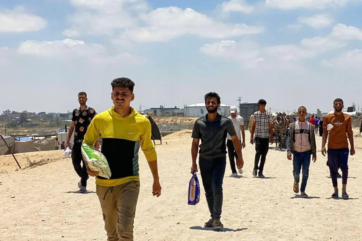 Displaced Palestinians, some carrying a bag of rice, return from an aid distribution center in Khan Younis in the southern Gaza Strip on May 28, 2025. (AFP)