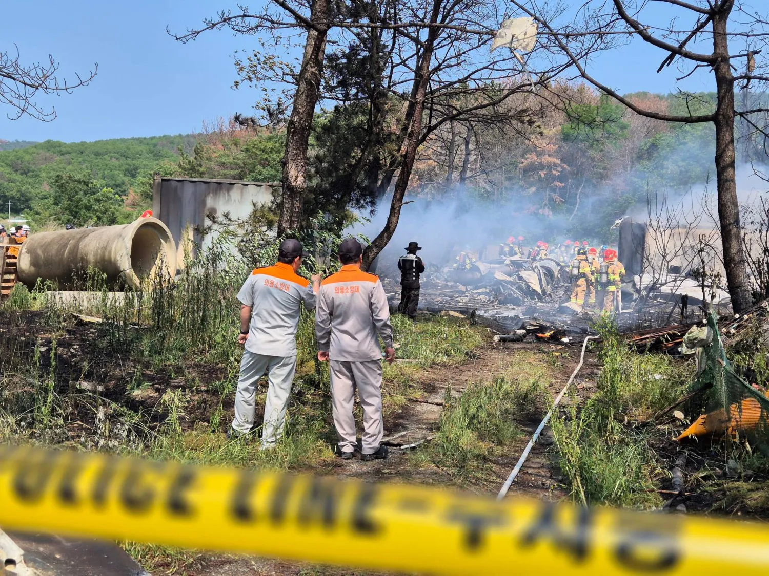 رجال إطفاء يعملون على إخماد حريق جراء تحطم طائرة تابعة للبحرية الكورية الجنوبية (رويترز)