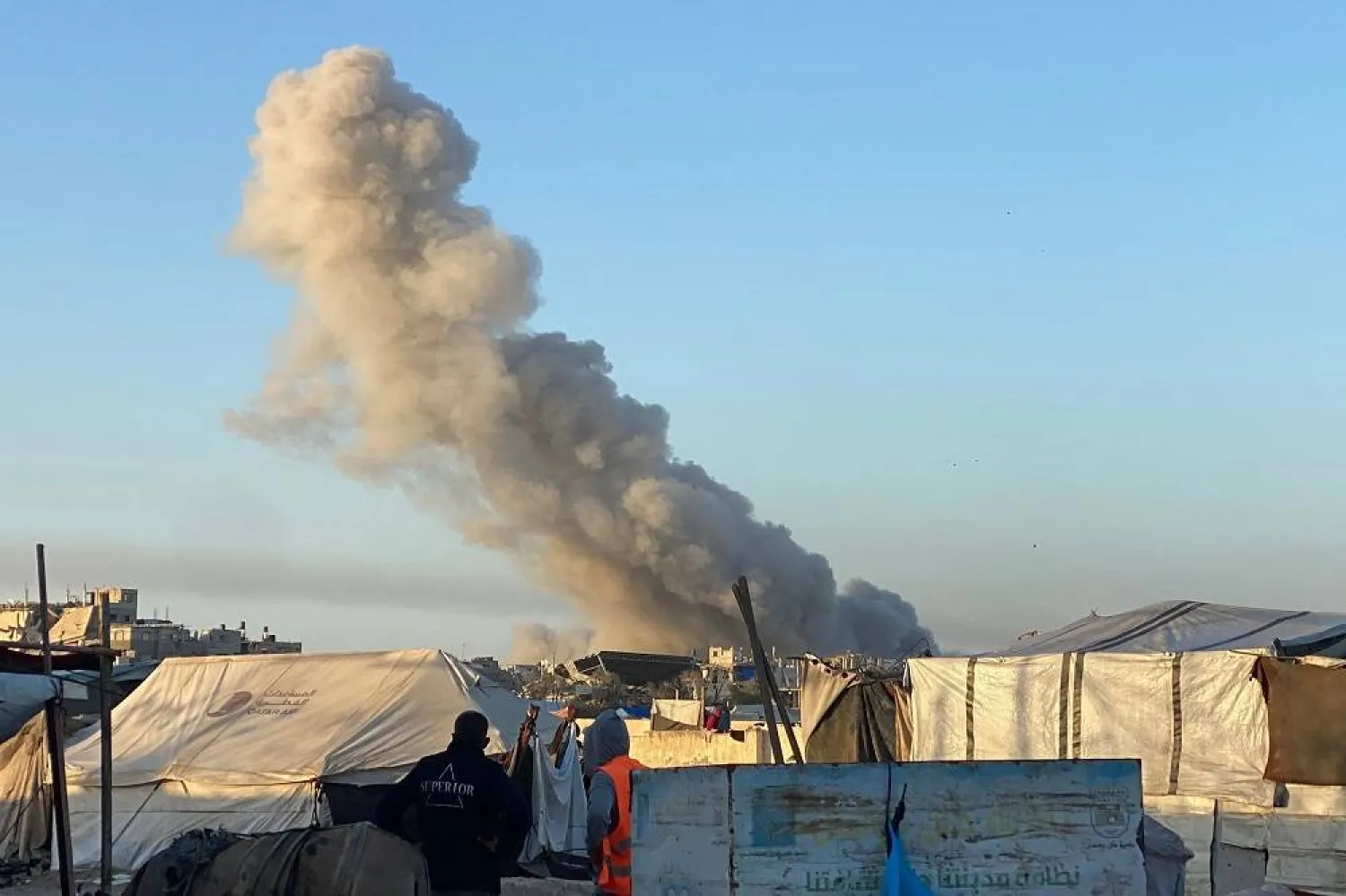 Smoke from an Israeli strike billows in the background as pictured from a camp housing displaced Palestinians, in Rafah in the southern Gaza Strip on May 29, 2025. (AFP)