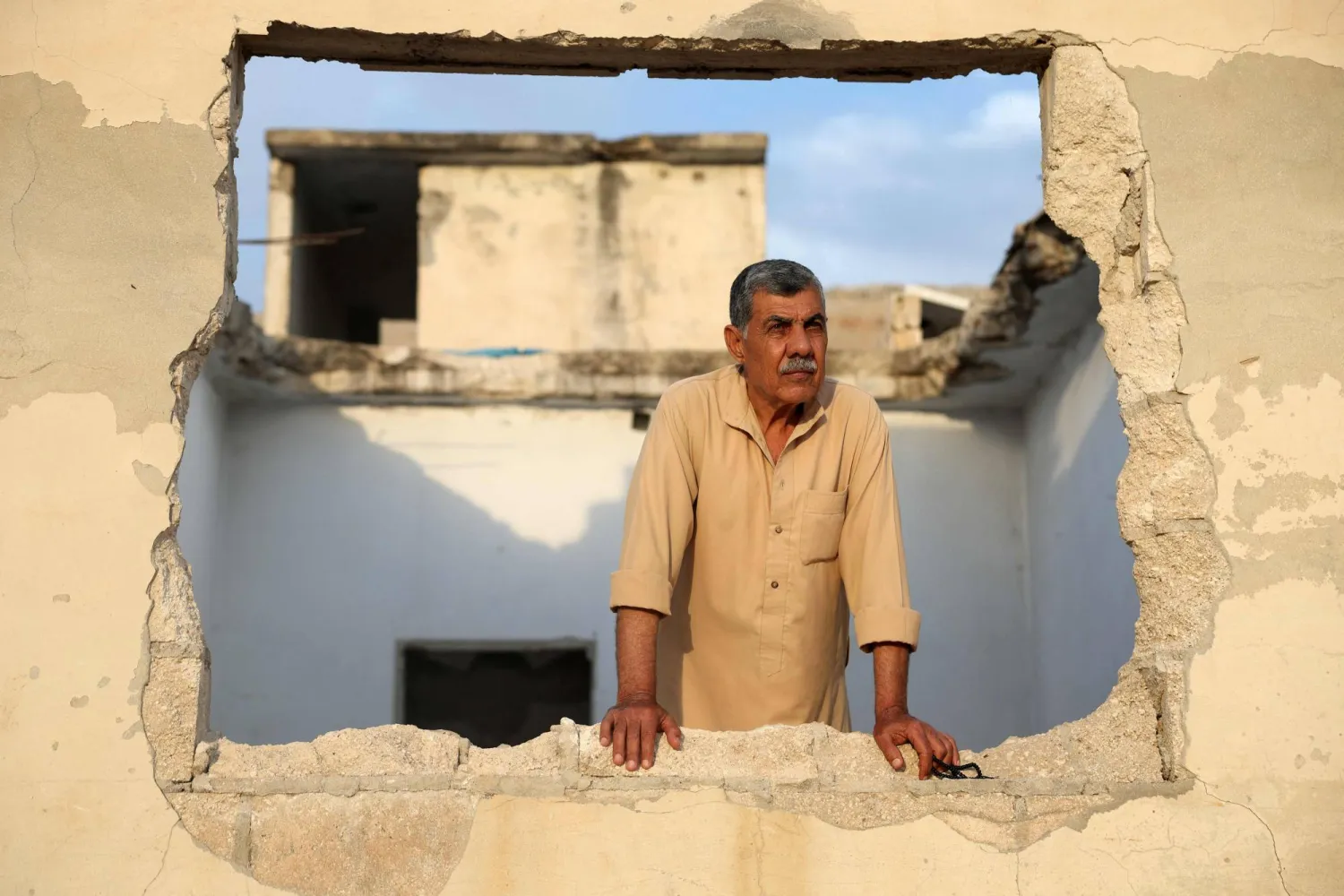 عارف شمطان داخل بيته المدمر في قرية الحواش بمحافظة حماة في 22 مايو 2025 (أ.ف.ب)