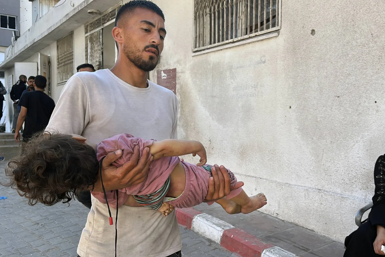 فلسطيني يحمل جثة طفل قضى بعد ضربة إسرائيلية لجباليا في شمال قطاع غزة، 29 مايو 2025 (د.ب.أ)