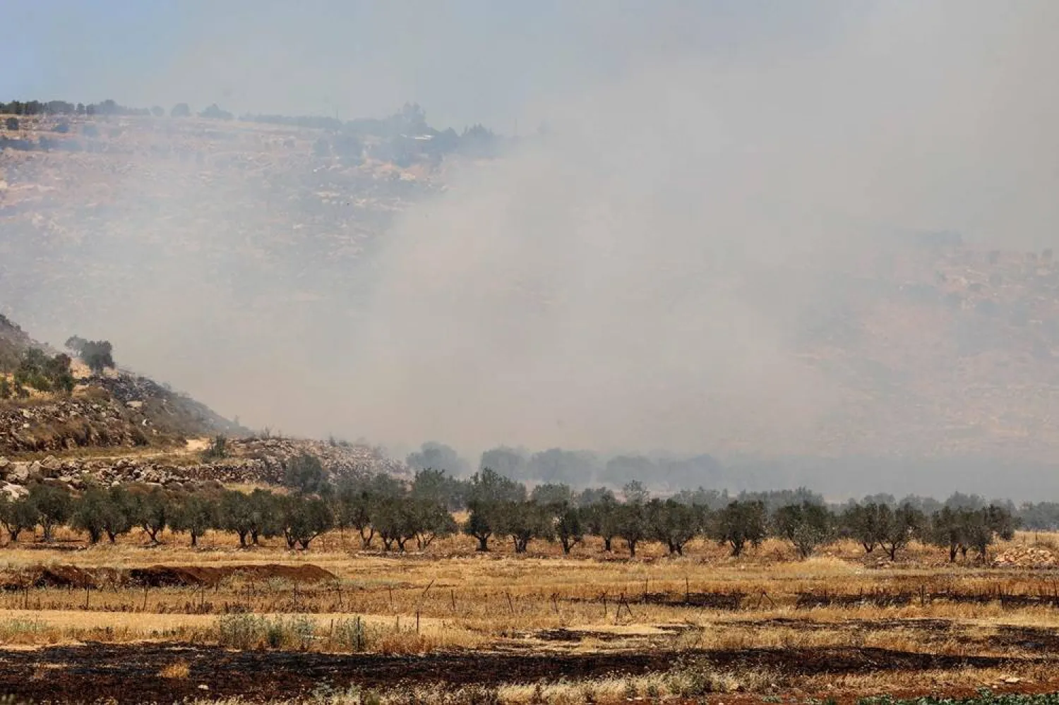 Smoke billows after Israeli settlers reportedly started a fire at on olives field in the Palestinian Khirbet Abu Falah village northeast of Ramallah in the occupied-West Bank, on May 28, 2025. (AFP)