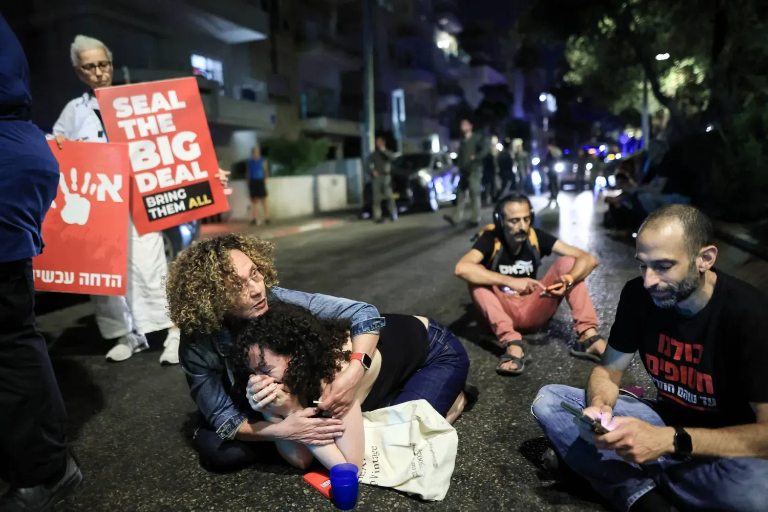 İsrailliler, Yemen'den fırlatılan bir füze nedeniyle Tel Aviv'de sirenler çalarken korunmak için yere oturuyor (Reuters)