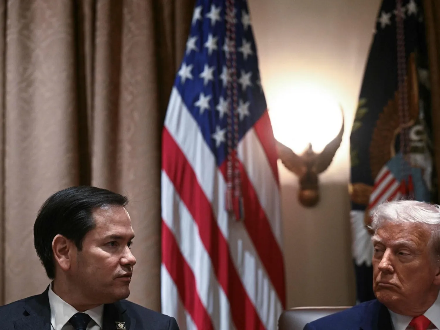 الرئيس الأميركي دونالد ترمب يستمع إلى وزير الخارجية ماركو روبيو في أثناء اجتماع وزاري في البيت الأبيض يوم 10 أبريل (أ.ف.ب)