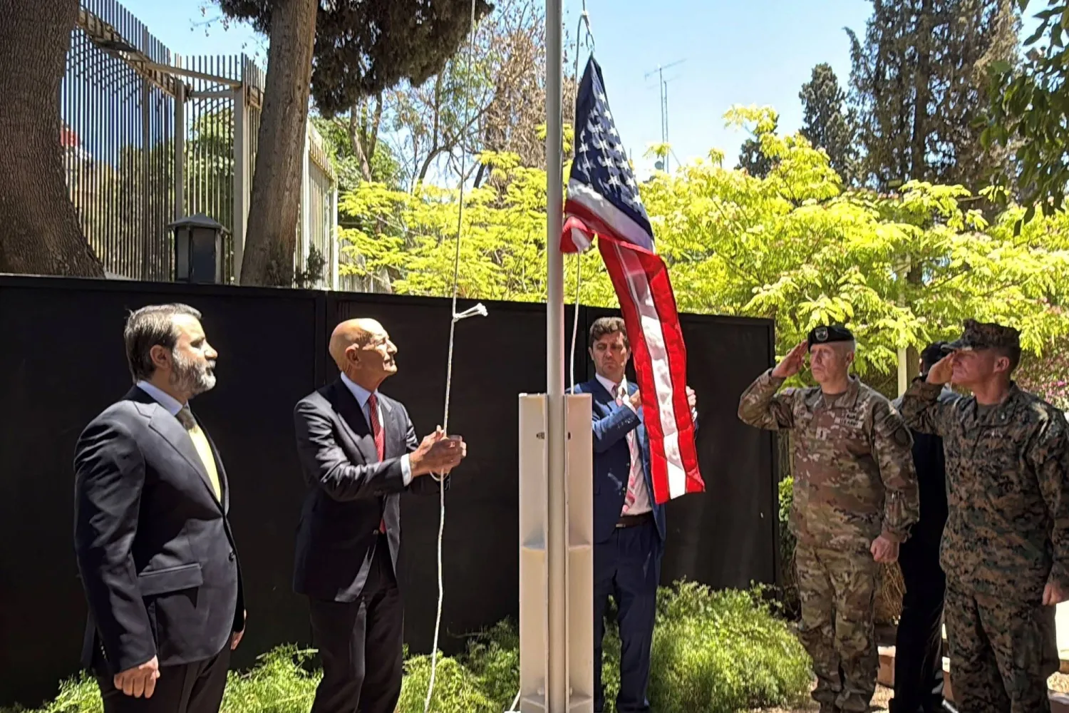 المبعوث الأميركي توماس برّاك يرفع علم بلاده بحضور وزير الخارجية السوري أسعد الشيباني في دمشق أمس (أ.ف.ب)