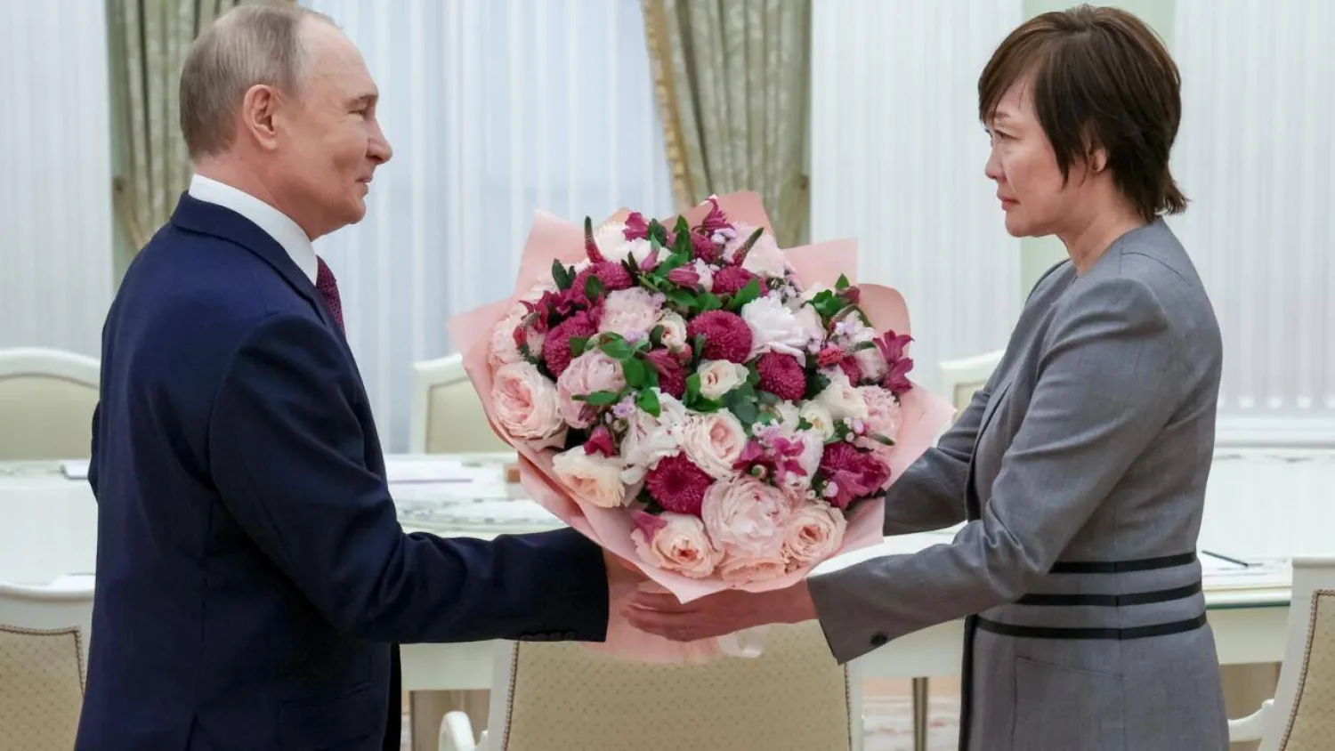 In this pool picture distributed by the Russian state agency Sputnik, Russia's President Vladimir Putin gives a bunch of flowers to Akie Abe, widow of former Japanese premier Shinzo Abe, at the Kremlin. Vyacheslav PROKOFYEV / POOL/AFP
