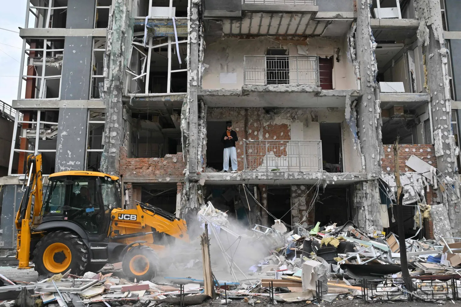 A local resident stands in a damaged flat of a multistory residential building following a drone strike in Kyiv on May 25, 2025, amid Russian invasion in Ukraine. (Photo by Sergei SUPINSKY / AFP)
