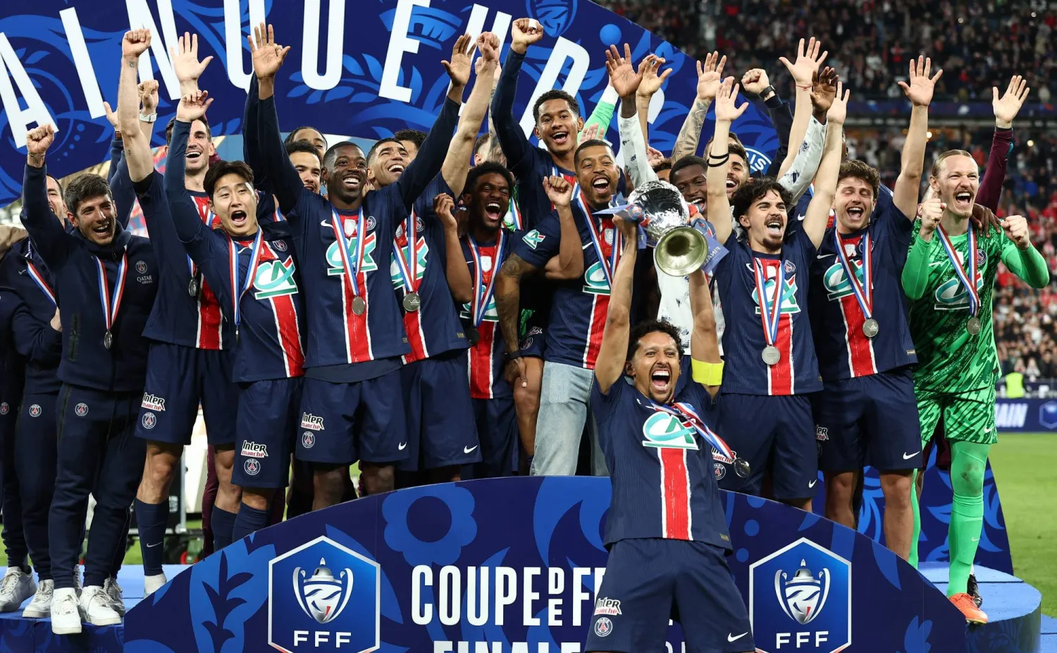 Paris Saint-Germain's Brazilian defender #05 Marquinhos (C) raises the trophy as he celebrates with teammates after winning French Cup final football match between Paris Saint-Germain (PSG) and Stade de Reims at the Stade de France in Saint-Denis, north of Paris, on May 24, 2025. (Photo by FRANCK FIFE / AFP)