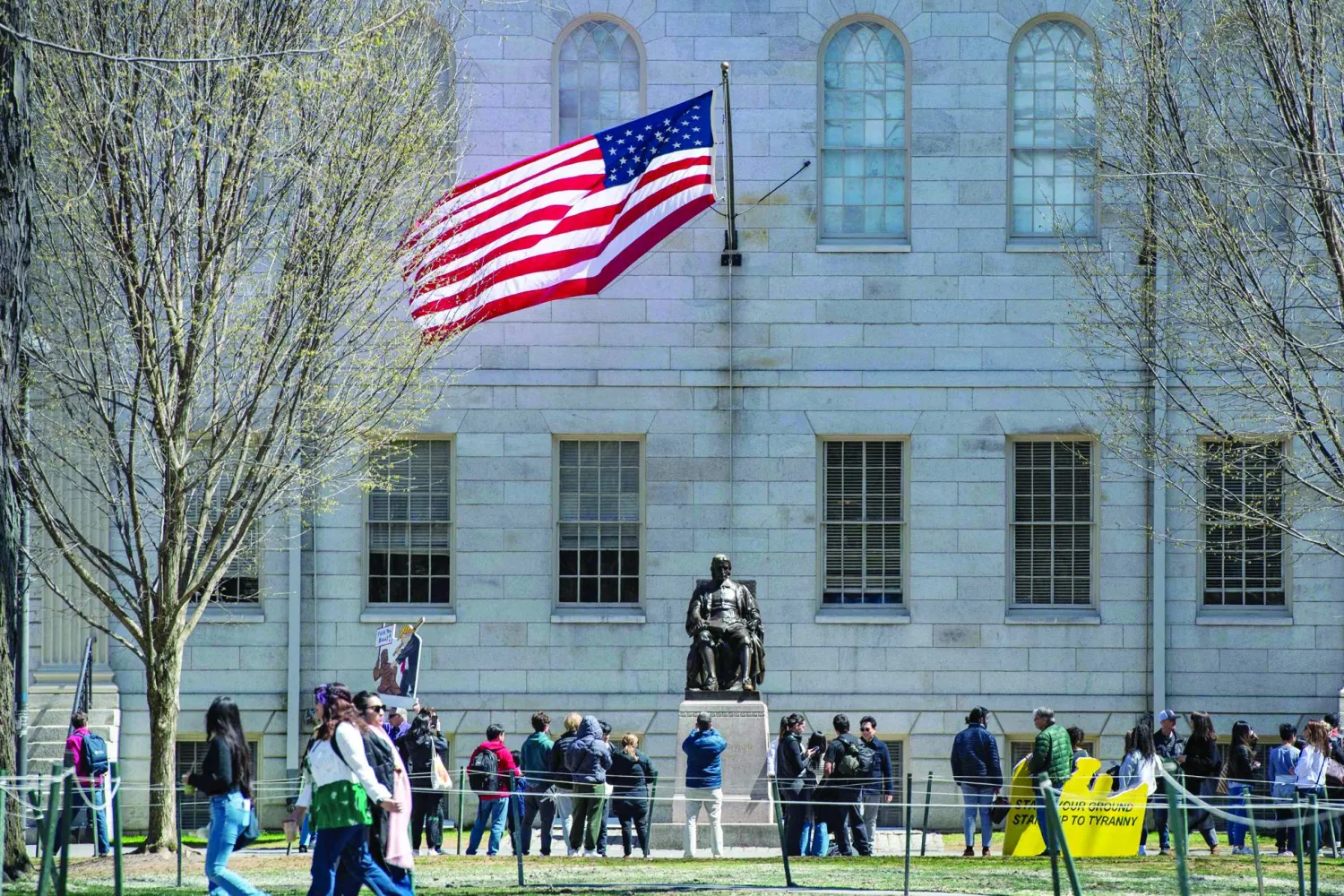 (FILES) Demonstrators with signs stand around the John Harvard Statue in Harvard Yard following a rally against President Donald Trump's attacks on Harvard University at Harvard University in Cambridge, Massachusetts on April 17, 2025. (Photo by Joseph Prezioso / AFP)