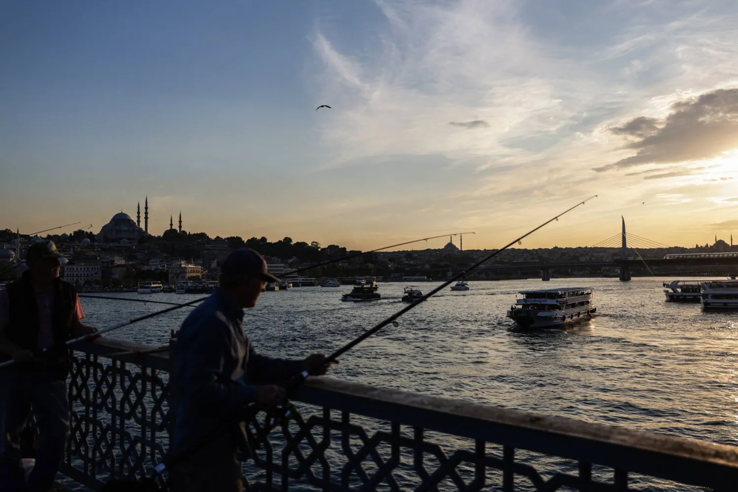 People fish on the Galata Bridge backdropped by the Suleymaniye Mosque during sunset in Istanbul, Türkiye, 28 May 2025. EPA/ERDEM SAHIN