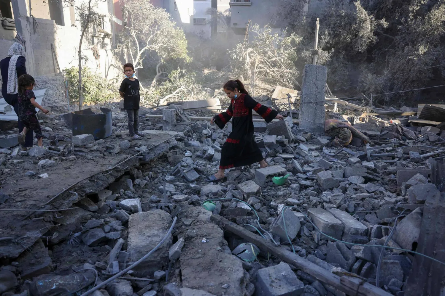 A girl walks above debris as Palestinians check the site of an overnight Israeli strike, in Jabalia in the central Gaza Strip, on May 30, 2025, amid the war between Israel and the Palestinian Hamas militant movement. (Photo by Bashar TALEB / AFP)