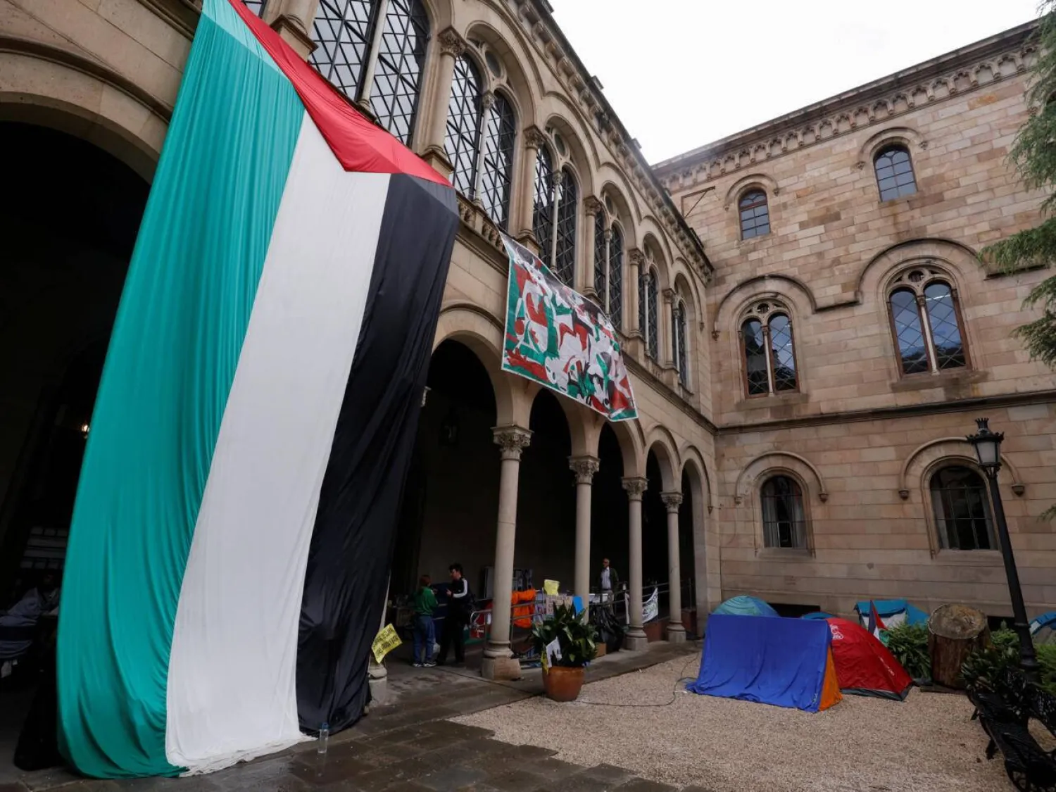 علم فلسطين معلق في مخيم طلابي بجامعة برشلونة دعماً للفلسطينيين في غزة (أرشيفية - رويترز)