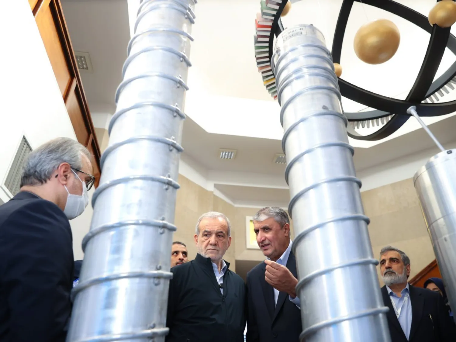 إسلامي يشرح للرئيس الإيراني مسعود بزشكيان نماذج من أجهزة الطرد المركزي في معرض للبرنامج النووي الشهر الماضي (الرئاسة الإيرانية)