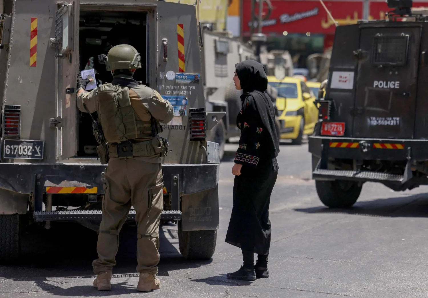 قوة إسرائيلية تعتقل سيّدة تعمل في محل للصيرفة بمدينة الخليل في الضفة الغربية المحتلة (أ.ف.ب)