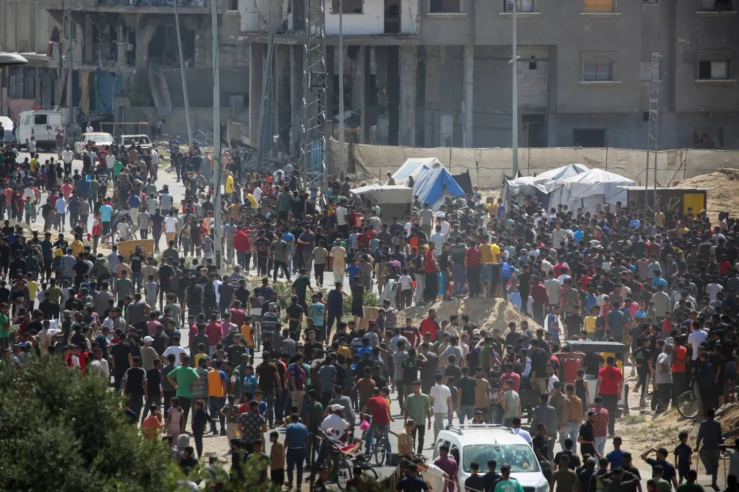 نازحون فلسطينيون خارج مستودع لبرنامج الأغذية العالمي في دير البلح بوسط قطاع غزة (أ.ف.ب)