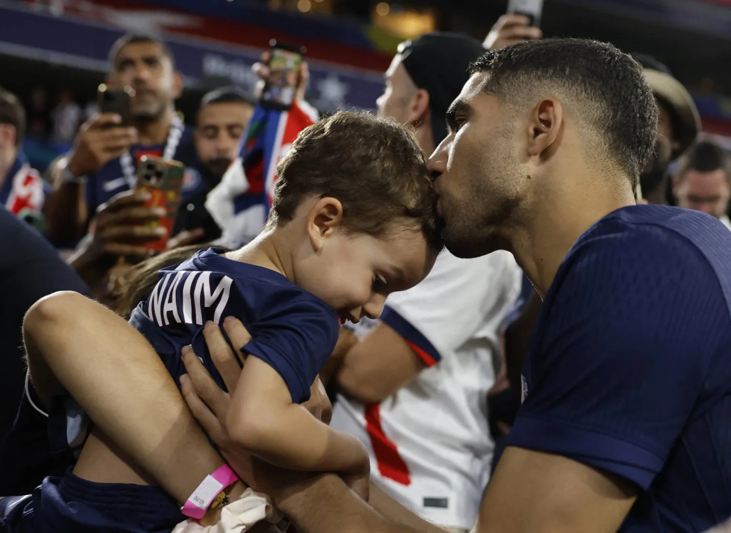 حكيم يقبل ابنه نعيم عقب الفوز في النهائي الأوروبي (رويترز)