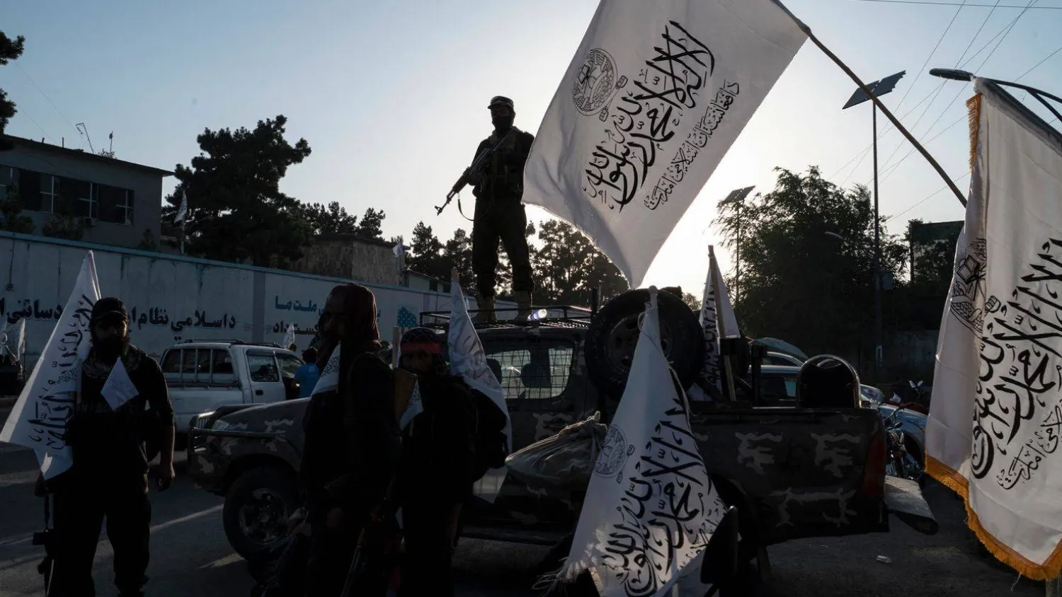 أفراد أمن من «طالبان» يرفعون علم الحركة (غيتي)