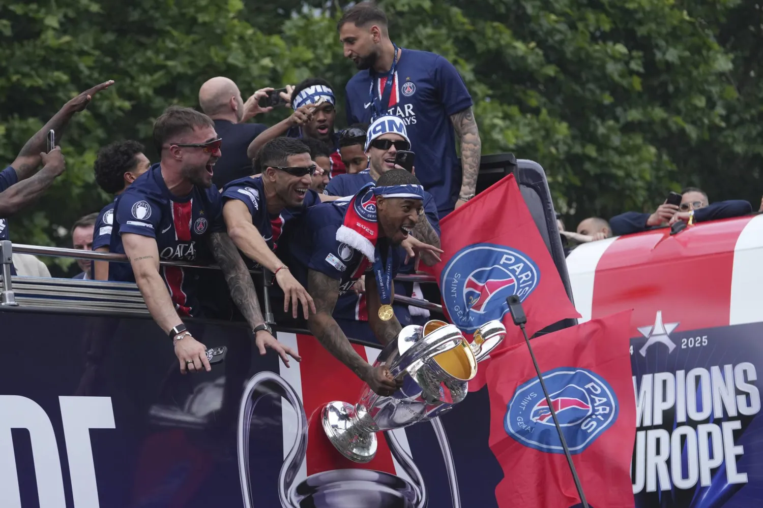 لاعبو سان جيرمان في الحافلة المكشوفة التي طافت بهم في جادة الشانزليزيه (أ.ب)