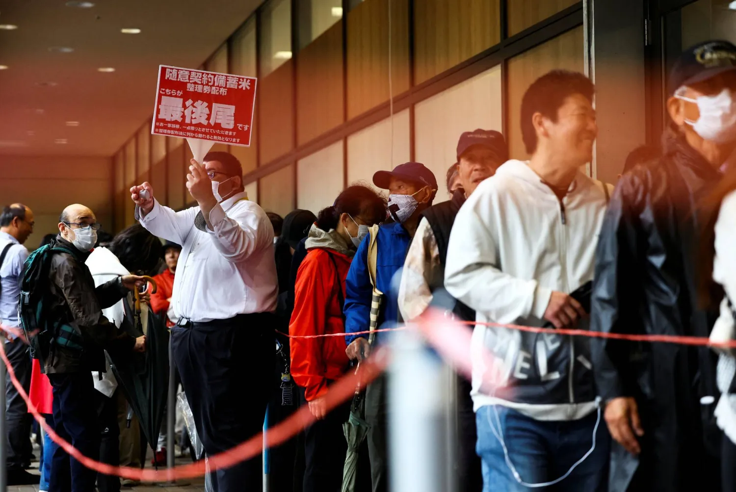يابانيون يصطفون في العاصمة طوكيو للحصول على حصص من مخزونات الأرز التي أفرجت عنها الحكومة بعد غلاء الأسعار (رويترز)