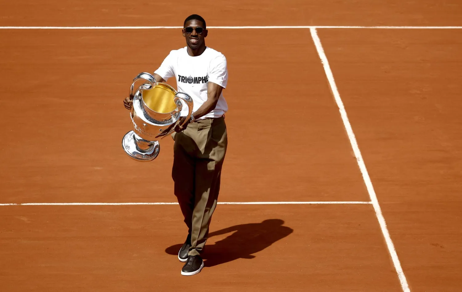 عثمان ديمبلي يحمل كأس أبطال أوروبا في ملاعب «رولان غاروس» (إ.ب.أ)