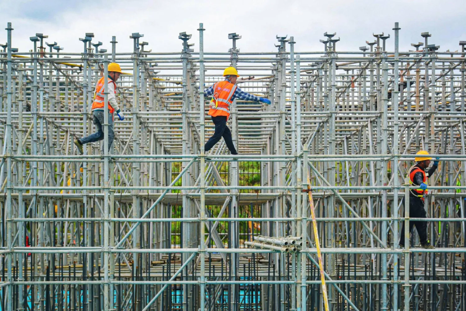 عمال بناء في موقع إنشاءات بمحطة قطارات في مدينة أنقينغ شرق الصين (أ.ف.ب)