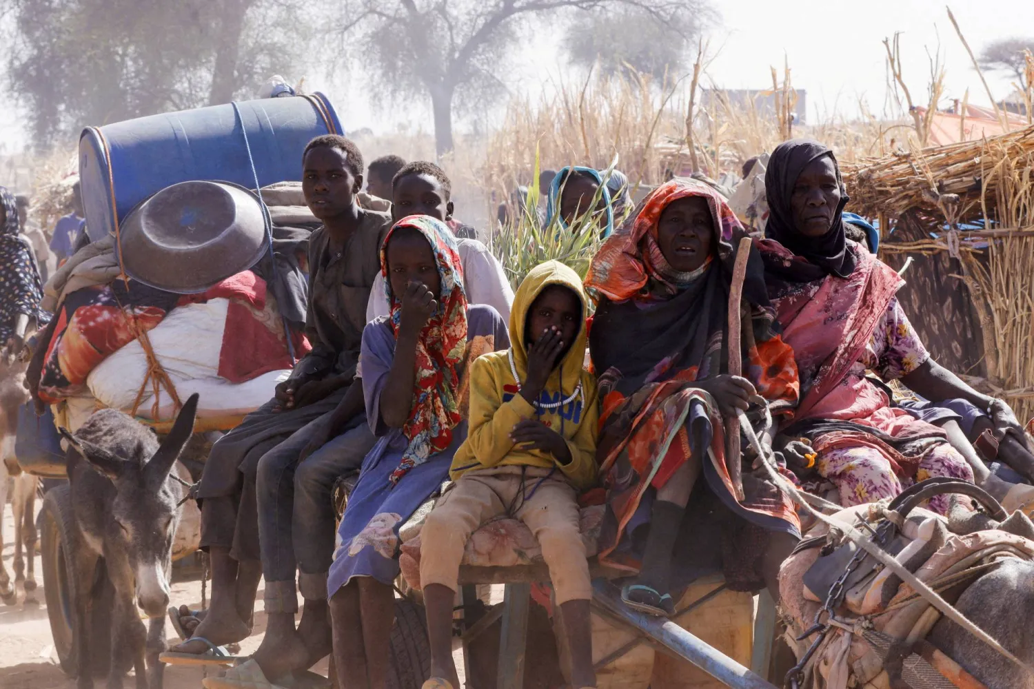 نازحون يركبون عربة تجرها حيوانات في شمال دارفور بالسودان (رويترز)