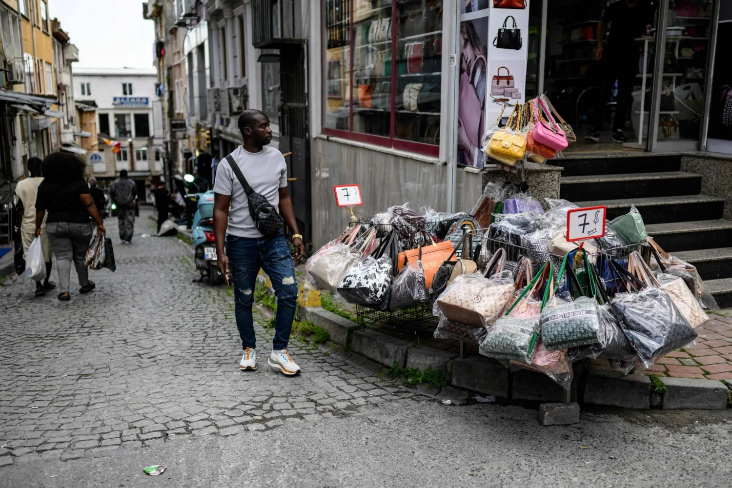 سائح يعاين أسعار الحقائب النسائية بمنطقة تجارية في إسطنبول (أ.ف.ب)