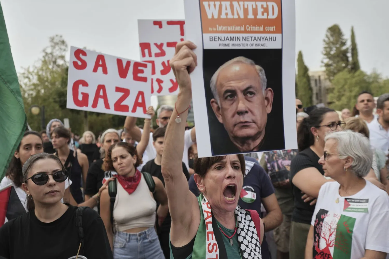 امرأة تحمل صورة لرئيس الوزراء الإسرائيلي بنيامين نتنياهو خلال احتجاج خارج القصر الرئاسي في نيقوسيا بقبرص (أ.ب)