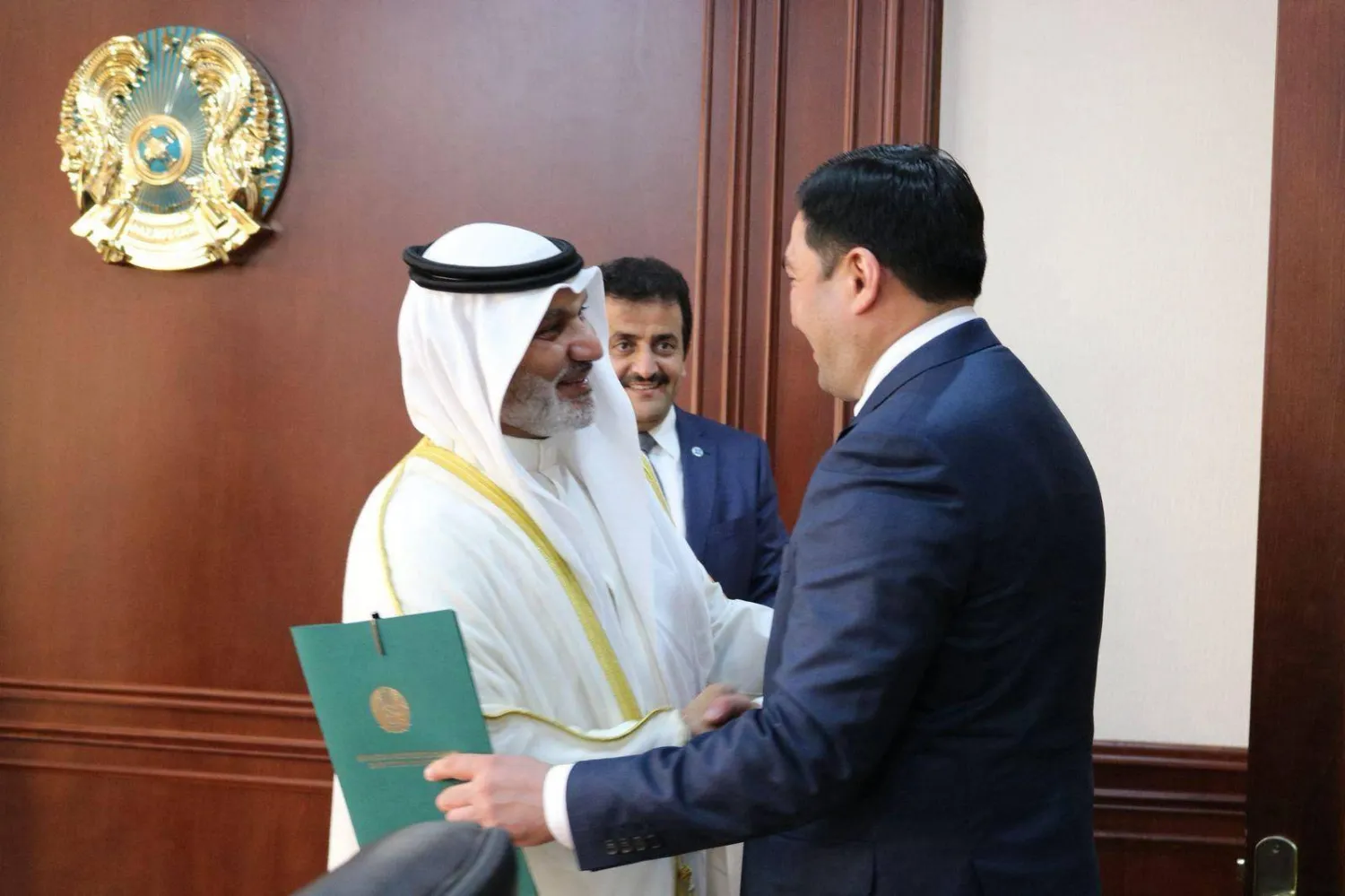 الغيص ووزير الطاقة الكازاخستاني يتصافحان قبل لقائهما في آستانة (أكس)