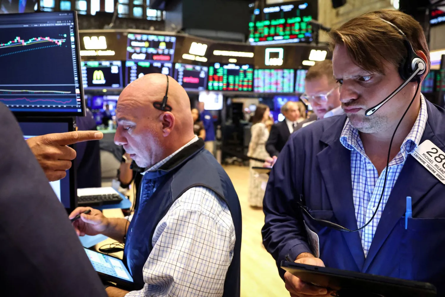 عاملون خلال ساعات التداول في بورصة نيويورك (رويترز)