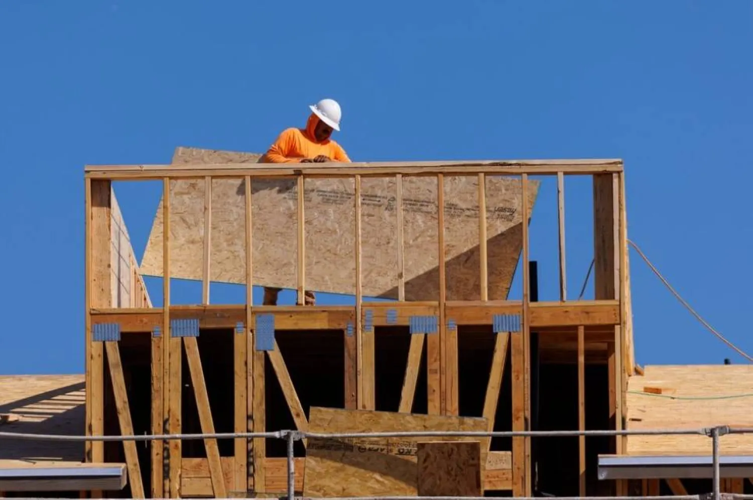 عامل بموقع بناء منازل سكنية جديدة قيد الإنشاء في فيستا بكاليفورنيا (رويترز)