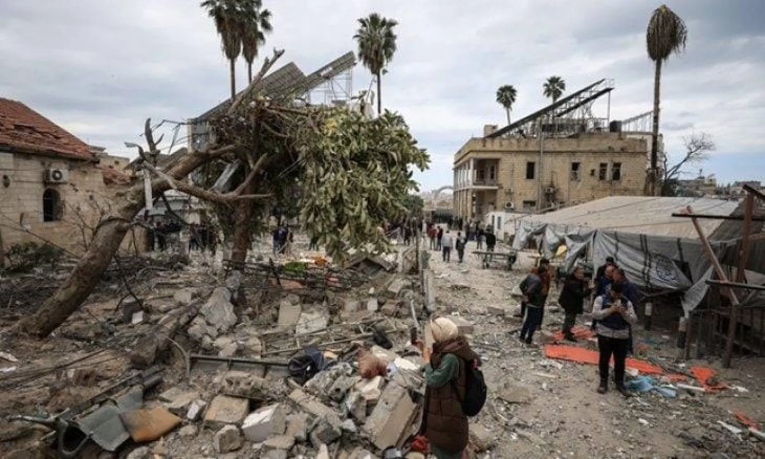 فلسطينيون يتفقدون الأضرار بعد سقوط صاروخين إسرائيليين على مبنى داخل «المستشفى المعمداني» في غزة يوم 13 أبريل 2025 (رويترز)