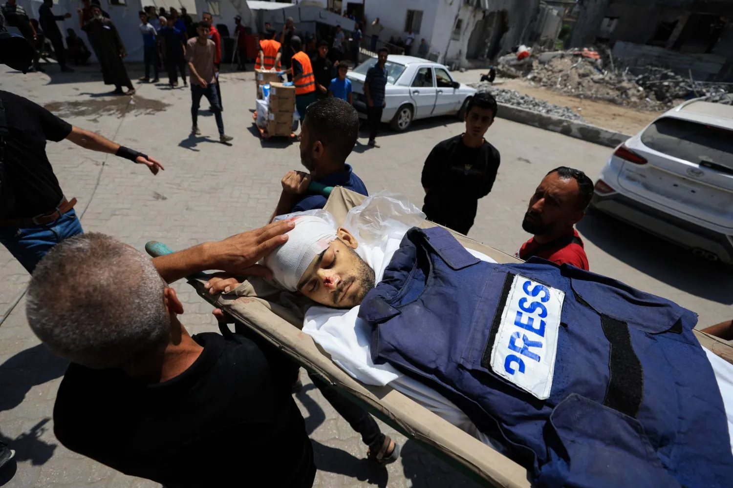 يحملون جثة الصحافي الفلسطيني إسماعيل بده الذي قتل في غارة اليوم على مستشفى الأهلي في غزة (رويترز)