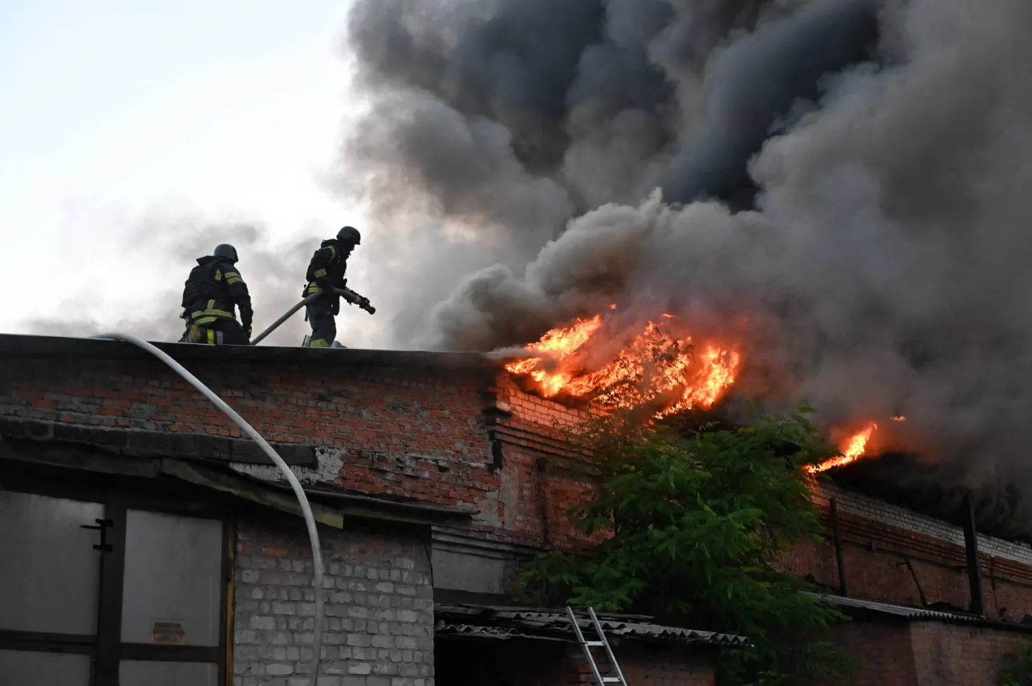رجال إنقاذ أوكرانيون يعملون على إخماد حريق اندلع بمبنى إثر غارة جوية على خاركيف يوم 4 يونيو 2025 في خضم الغزو الروسي لأوكرانيا (أ.ف.ب)