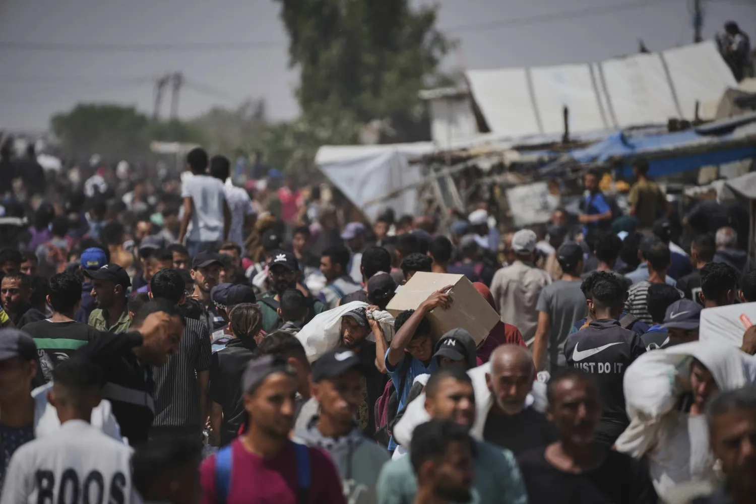 يحمل فلسطينيون صناديق وأكياساً تحتوي على مساعدات غذائية وإنسانية قدمتها «مؤسسة غزة الإنسانية» وهي منظمة مدعومة من الولايات المتحدة ووافقت عليها إسرائيل في رفح (أ.ب)