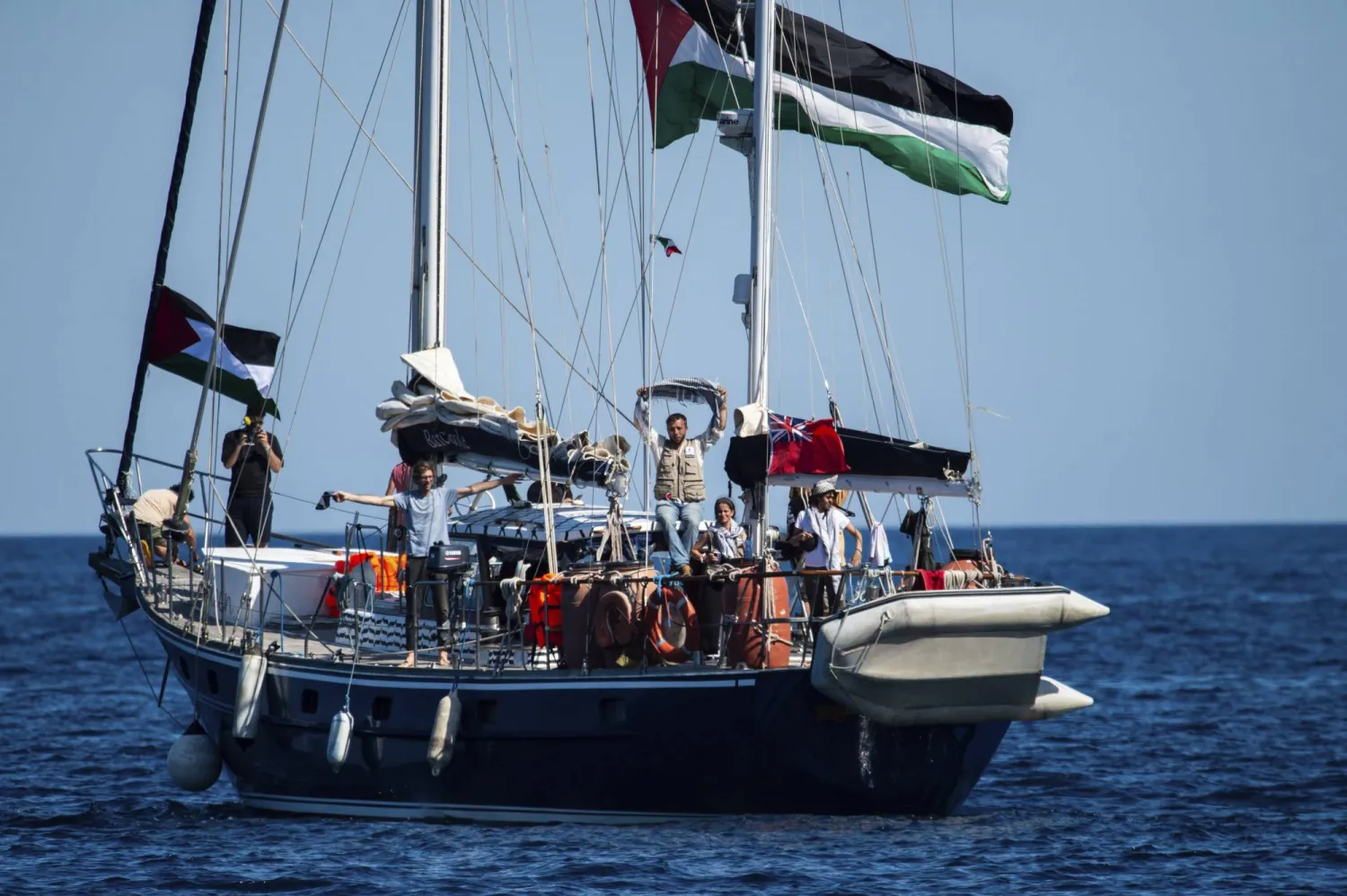 ناشطون على متن السفينة «مادلين» التابعة لـ«أسطول الحرية» بعد إبحارها من مرفأ كاتانيا في جزيرة صقلية الإيطالية (أ.ب)