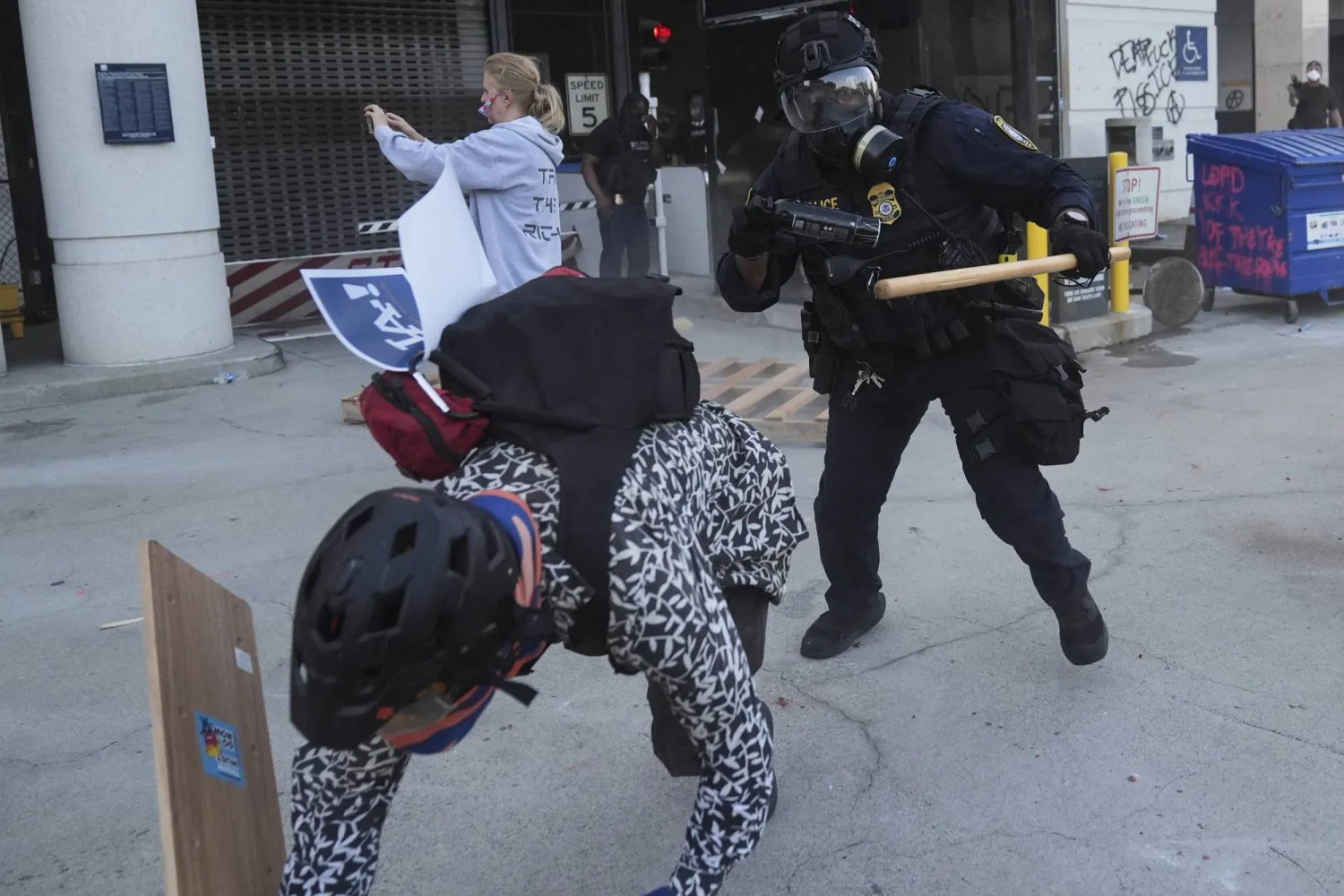 متظاهر يهرب من أحد ضباط الأمن الداخلي في لوس أنجليس خلال مظاهرة أمام مركز احتجاز اتحادي (أ.ب)