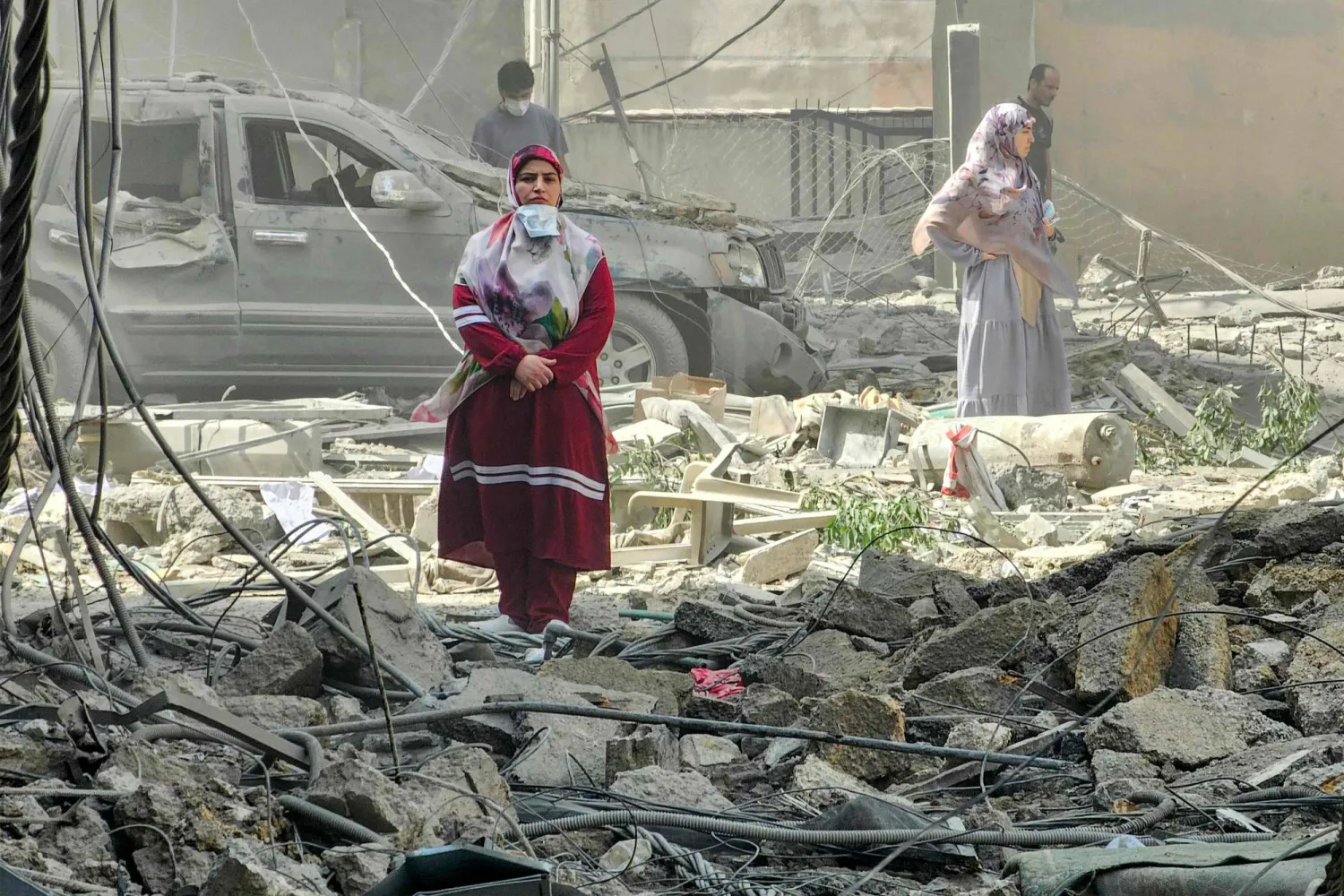 سيدة تجول بين الدمار الذي خلفه القصف الإسرائيلي على الضاحية الجنوبية لبيروت مساء الخميس (أ.ف.ب)