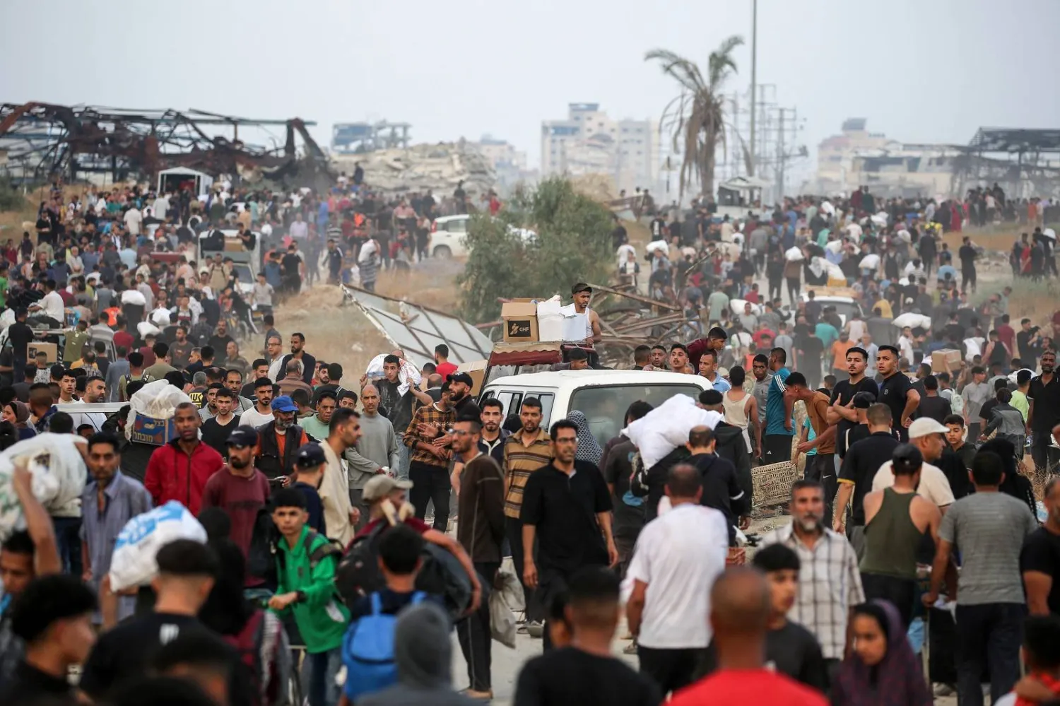 فلسطينيون وسط غزة يترقّبون إمدادات إغاثية من مؤسسة غزة الإنسانية قرب مركز توزيع مساعدات (أ.ف.ب)