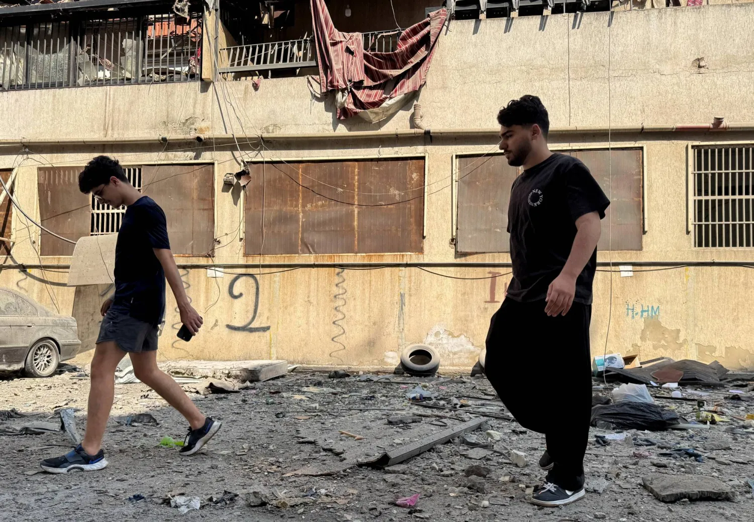 
مواطنان يتفقدان الدمار الذي خلّفه القصف الإسرائيلي على الضاحية الجنوبية لبيروت (رويترز)